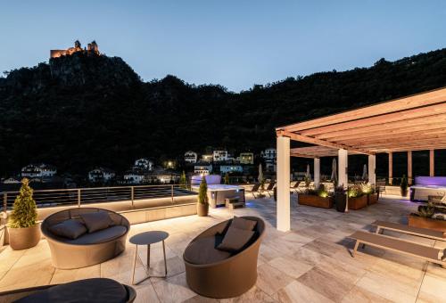 a patio with chairs and tables on a roof at Hotel Klostersepp in Chiusa