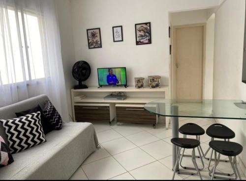 a living room with a couch and a glass table at Apartamento Praia in Guarujá