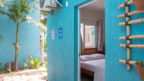 a blue room with a bed and a blue wall at Residencial Águas de Bare in São Sebastião