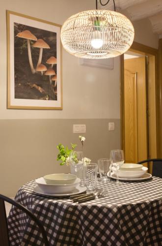 a dining table with a checkered table cloth and a chandelier at Apartamento Tarazona Centro in Tarazona de Aragón