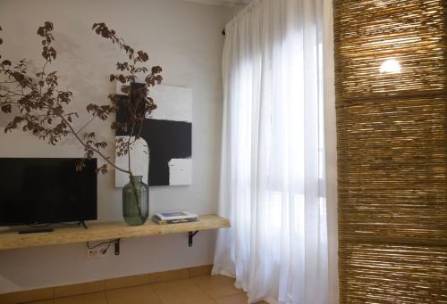 a living room with a television and a window at Apartamento Tarazona Centro in Tarazona de Aragón