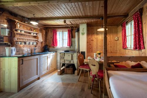 eine Küche mit Holzschränken und einem Tisch und Stühlen in der Unterkunft Wichtelhütte Silberregion Karwendel in Umlberg