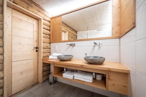 2 lavabos en un baño con paredes de madera en Wichtelhütte Silberregion Karwendel, en Umlberg