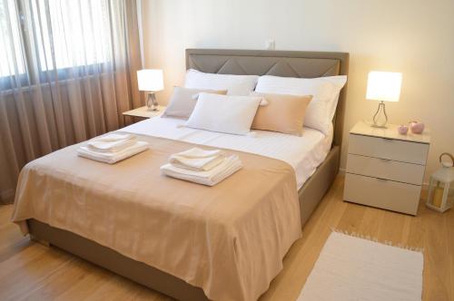 a bedroom with a large bed with towels on it at Rova Apartment in Malinska