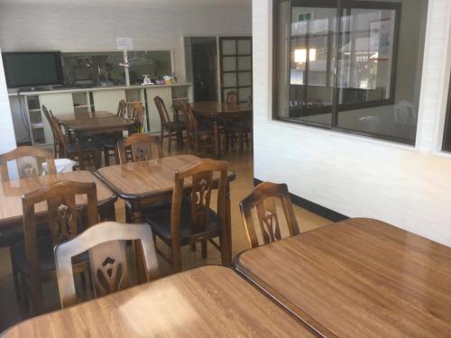 uma sala de jantar com mesas e cadeiras de madeira em Homestay Dream - Vacation STAY 2388 em Minami Uonuma