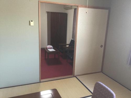 Habitación con puerta, mesa y silla en Homestay Dream - Vacation STAY 2666, en Minami Uonuma