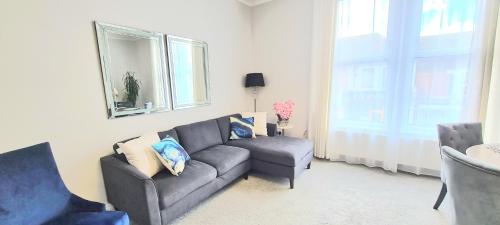 a living room with a couch and a chair at Spacious 3 bed flat near the sea with parking in Bournemouth
