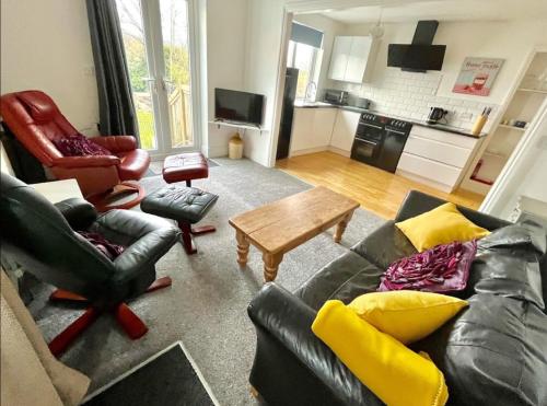 ein Wohnzimmer mit einem Sofa, Stühlen und einem Tisch in der Unterkunft Superb Garden Suite at The Moorings Shaldon in Shaldon