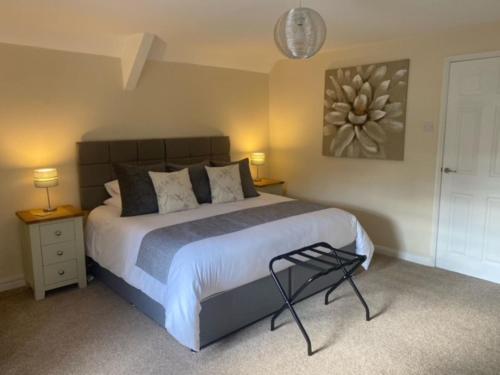 a bedroom with a large bed and two tables and a lamp at 2 Mews Cottages - Town Centre Location in Appleby