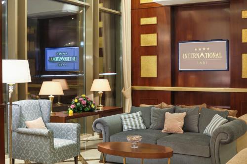 a living room with a couch and two chairs at Hotel International Iasi in Iaşi