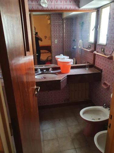 a bathroom with a sink and a toilet and a mirror at Apartamentos Plaza in Rosario