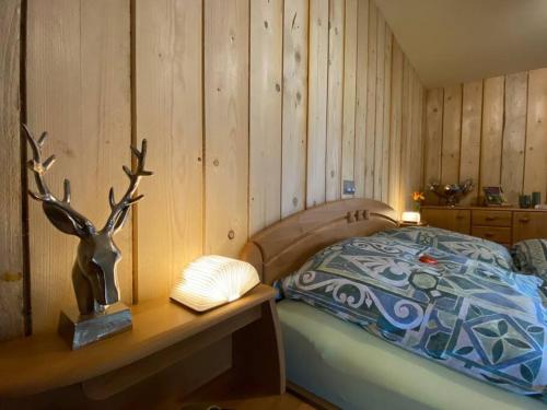 a bedroom with a bed and a wooden wall at Casita - Sterneferienhaus mit Garten, Sauna und Wallbox in Kirburg