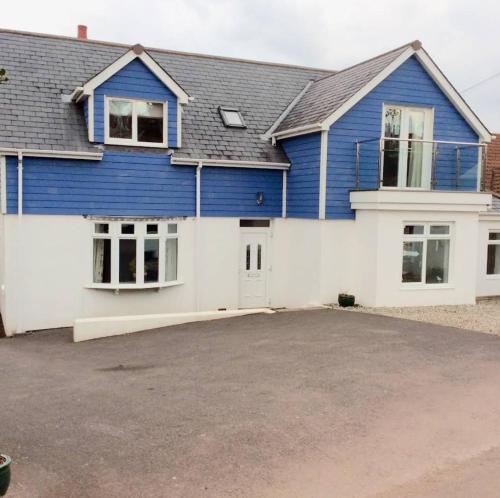 ein blau-weißes Haus mit Auffahrt in der Unterkunft Superb Garden Suite at The Moorings Shaldon in Shaldon