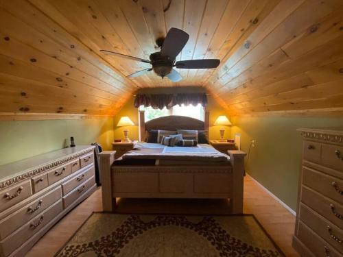 a bedroom with a large bed with a ceiling fan at Mountain Adventure Ski Chalet near Gore in Johnsburg