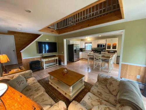 a living room with a couch and a table at Mountain Adventure Ski Chalet near Gore in Johnsburg