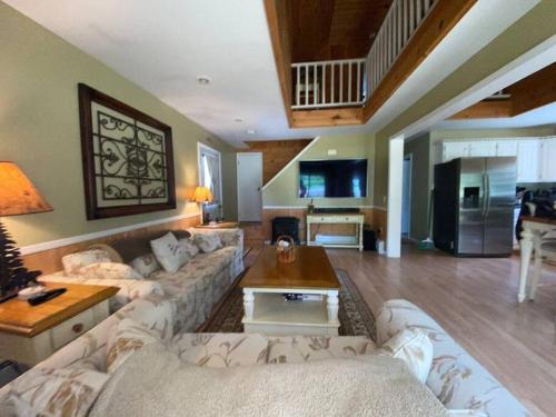 a large living room with couches and a table at Mountain Adventure Ski Chalet near Gore in Johnsburg