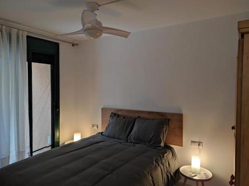 ein Schlafzimmer mit einem Bett mit zwei Lampen und einem Deckenventilator in der Unterkunft Mar y Montaña - l'Hospitalet de l'Infant in Vandellòs i l’Hospitalet de l’Infant
