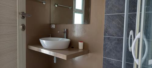 un baño con lavabo y espejo en KatlantiK Beach House Deluxe, en Sal Rei