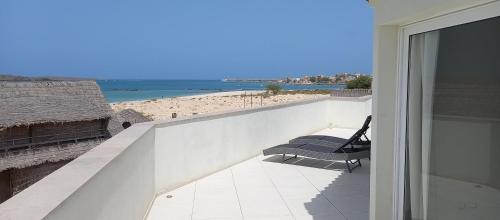 Un balcón con un banco y vista a la playa. en KatlantiK Beach House Deluxe, en Sal Rei