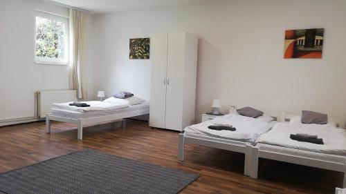 two beds in a room with wooden floors at Apartman Romy in Pančevo