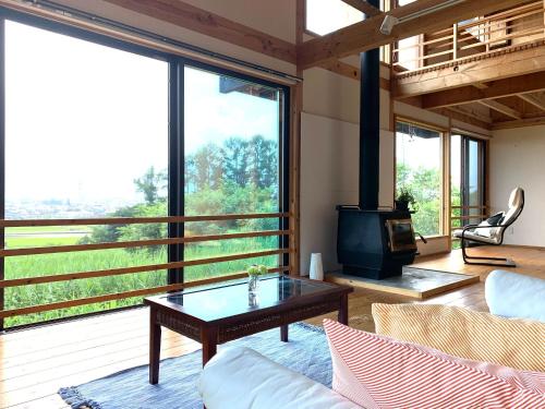 ein Wohnzimmer mit einem Sofa und einem Tisch in der Unterkunft Kitaarupusu ichibō no ie - Vacation STAY 96488v in Omachi