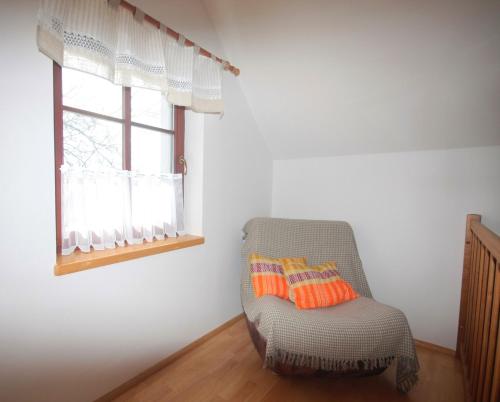 a chair in a room with a window at Apartmán V sadu in Míšov