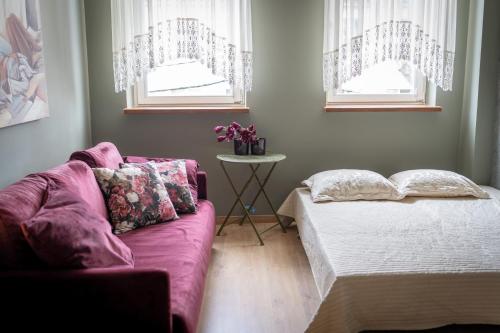 a living room with a couch and two windows at Pod Beczką in Augustów