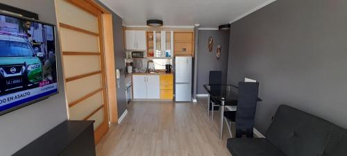 a living room with a television and a kitchen at Depto central in Viña del Mar