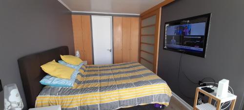 a small bedroom with a bed and a flat screen tv at Depto central in Viña del Mar