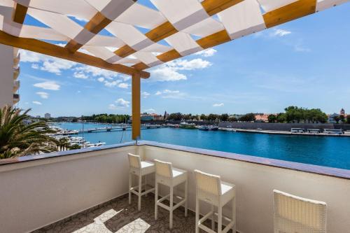 a balcony with chairs and a view of the water at B&B Giardin exclusive rooms and suite in Zadar