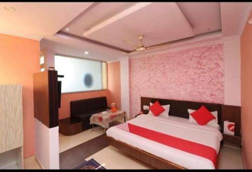 a bedroom with a large bed with red pillows at Hotel Rock View in Pachmarhī