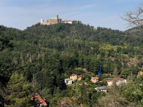 un castillo en la cima de una colina con casas en Ferienhaus Eisenach, en Eisenach