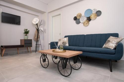 a living room with a blue couch and a table at Silvia's Apartments in Corfu Town