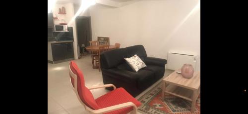 ein Wohnzimmer mit einem Sofa, Stühlen und einem Tisch in der Unterkunft Appartement dans uns corps de ferme in Follainville-Dennemont