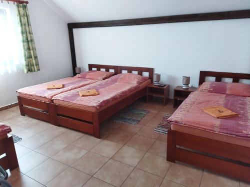 a bedroom with two beds and two tables in it at Vinný sklep a penzion U Vinohradu in Velké Bílovice