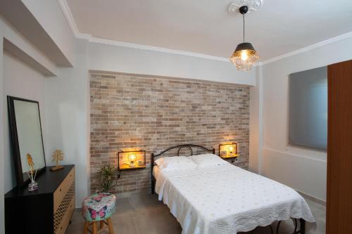 a bedroom with a bed and a brick wall at Silvia's Apartments in Corfu Town