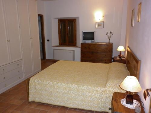 a bedroom with a bed and a television on a dresser at Podere Le Grotte in San Gimignano