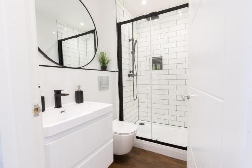 a white bathroom with a sink and a shower at Chester Stays - Lovely apartment in the heart of Chester with free parking in Chester