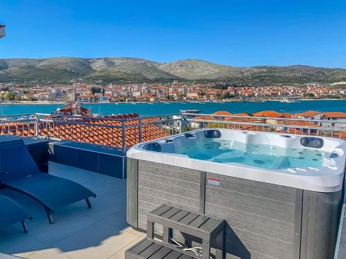 uma banheira de hidromassagem na varanda de um edifício em Apartments & Rooms Žaja em Trogir