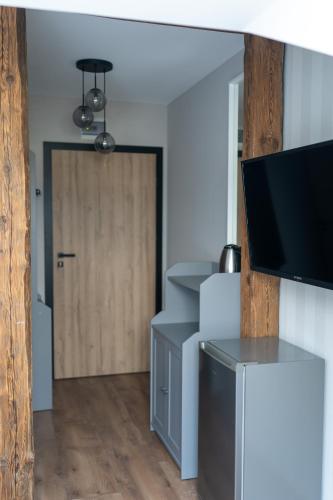 a room with a door with a television and a table at Pod Beczką in Augustów