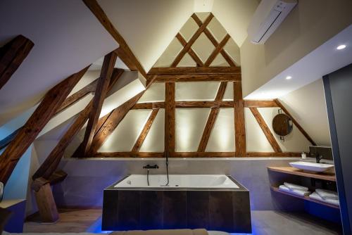 an attic bathroom with a tub and a sink at SERENITY Colmar - Gîtes de Prestige 4 et 5 étoiles - 2, 4 et 6 personnes- Centre Historique in Colmar