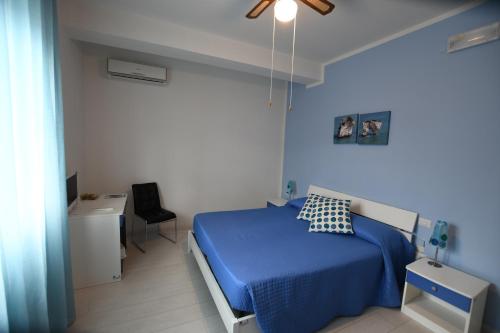 um quarto com uma cama azul e uma cadeira preta em Bed and breakfast Coppadicuocobb em Mattinata
