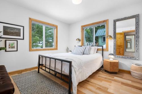 Un dormitorio con una cama y dos ventanas en Mountain Rose, en Government Camp