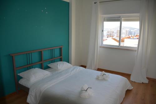 a bedroom with two beds with white sheets and a window at M&H Loft - Apartamento T2 em Setúbal in Setúbal