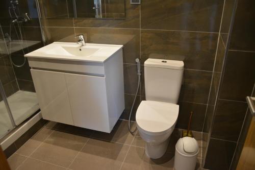 a bathroom with a white toilet and a sink at M&H Loft - Apartamento T2 em Setúbal in Setúbal