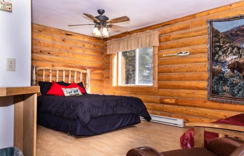 a bedroom with a bed in a log cabin at Half Moon Lake Lodge in Pinedale