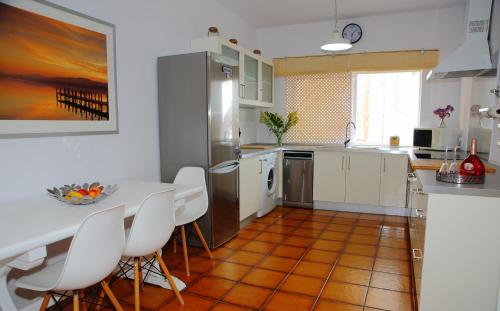 a kitchen with a white table and white chairs at Casa Miramar in Gran Tarajal