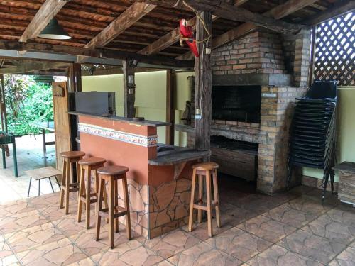 a bar with stools in front of a brick fireplace at Hosteria Helvecia in Montecarlo