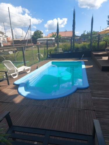 a blue swimming pool on a wooden deck at Casa de Pedra-Vale dos Vinhedos -RS in Monte Belo