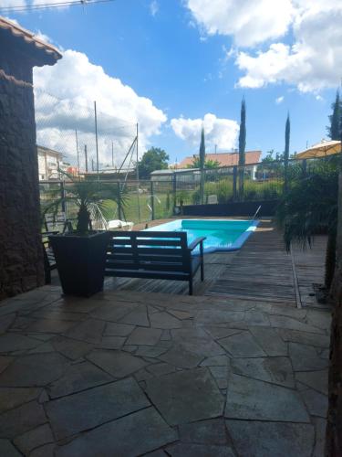 a swimming pool with a bench in a yard at Casa de Pedra-Vale dos Vinhedos -RS in Monte Belo